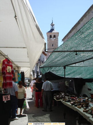 La torre de Iglesia desde la Plaza entre toldos un martes de mercadillo. 22-08-06