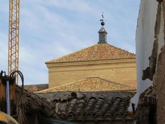 Los tejados nuevos de la Iglesia y los viejos de una casa en demolición vistos desde la Plaza del Pilar