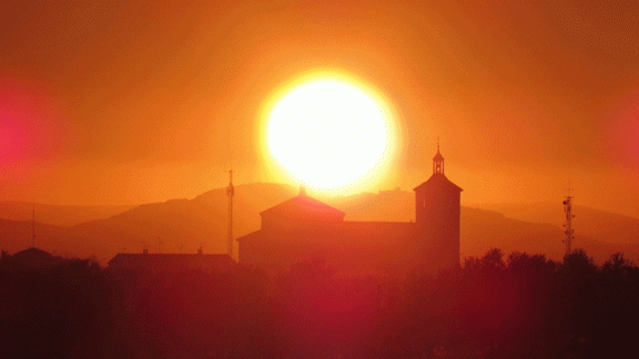 Puesta de sol desde camino las Navas sobre el castillo de Peñas Negras de Mora y sobre la torre de la Iglesia