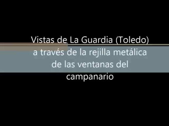 Vistas de La Guardia a través de la rejilla metálica de las ventanas que impide que las palomas entren en el campanario de la Iglesia
